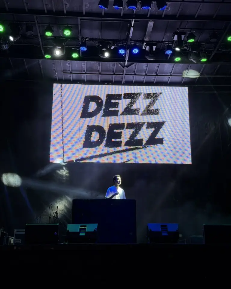 Escenario con una gran pantalla LED y focos de colores durante un festival