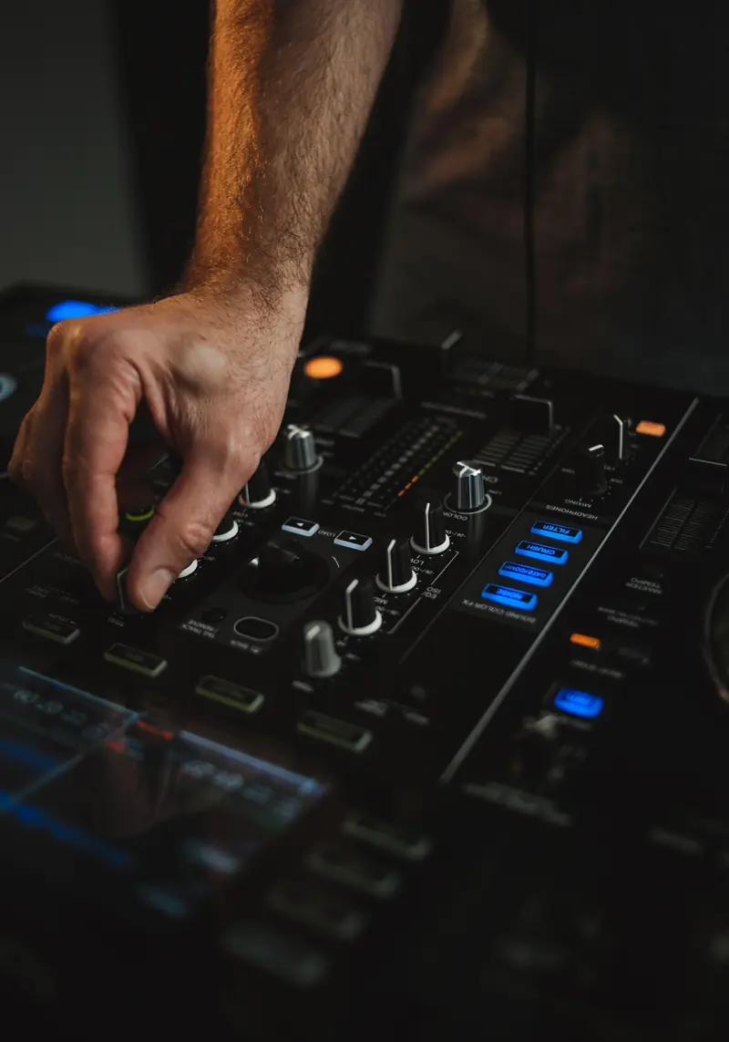 Primer plano de las manos de un DJ sobre una mesa de mezclas Pioneer