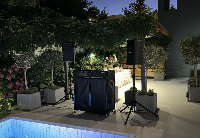 Equipo de sonido montado en el jardín de una casa junto a la piscina